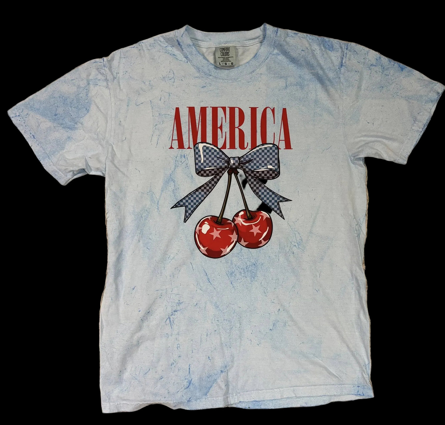 T-shirt with 'AMERICA' and cherry design on a textured surface