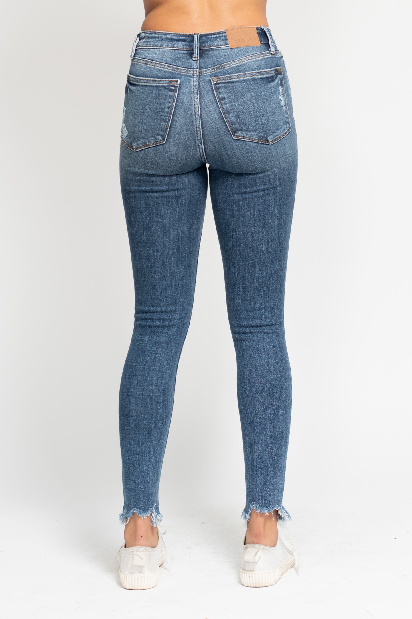 Blue jeans worn by a person on a white background