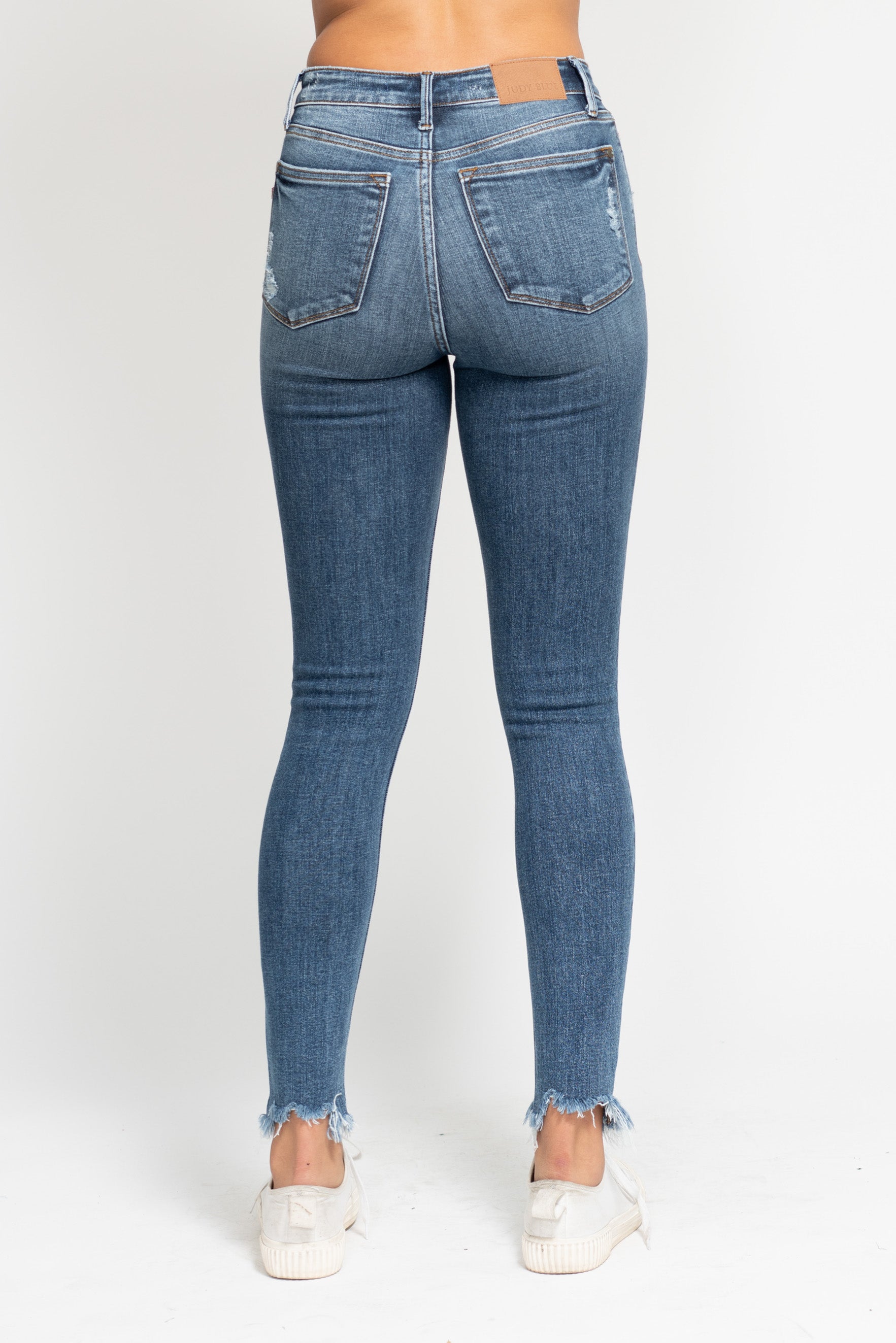 Blue jeans worn by a person on a white background