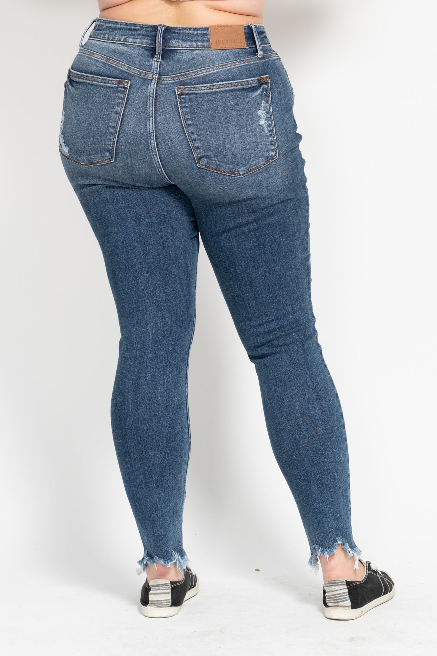 Blue jeans worn by a person on a white background