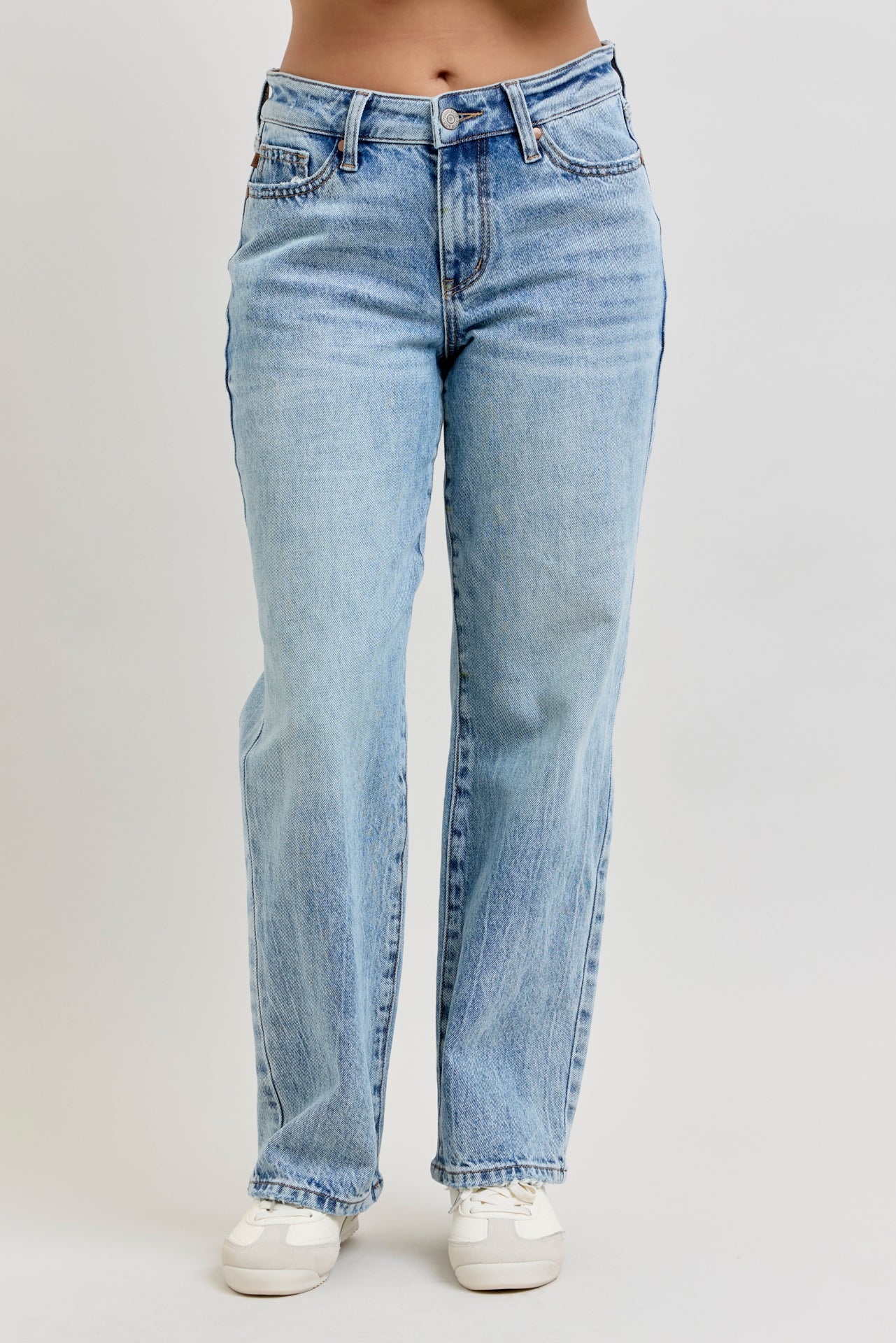 Light blue jeans worn by a person on a plain background