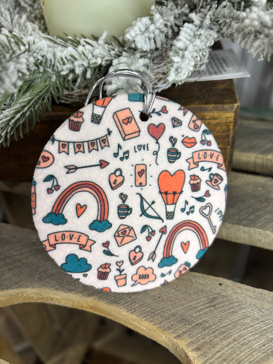 Decorative ornament with heart and arrow patterns on a wooden surface.