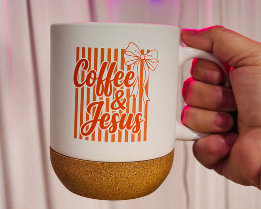 Hand holding a mug with 'Coffee & Jesus' text in front of a neon sign.