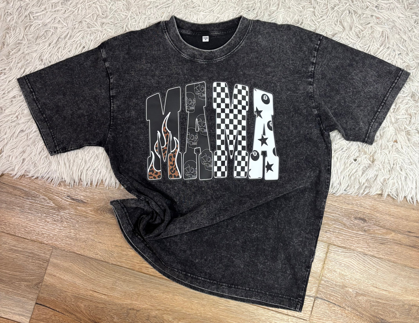 Black t-shirt with graphic design on a wooden floor