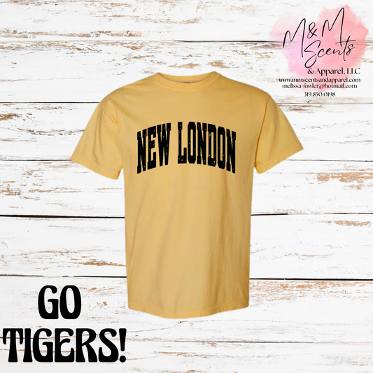 A yellow short-sleeve t-shirt with 'NEW LONDON' printed in black arched block letters across the chest, displayed on a white rustic wood plank background with 'GO TIGERS!' text and an 'M&M Scents Apparel LLC' logo overlay.