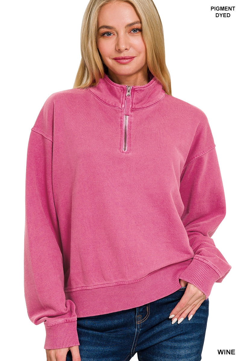 Woman wearing a pink pullover with a quarter zip on a white background