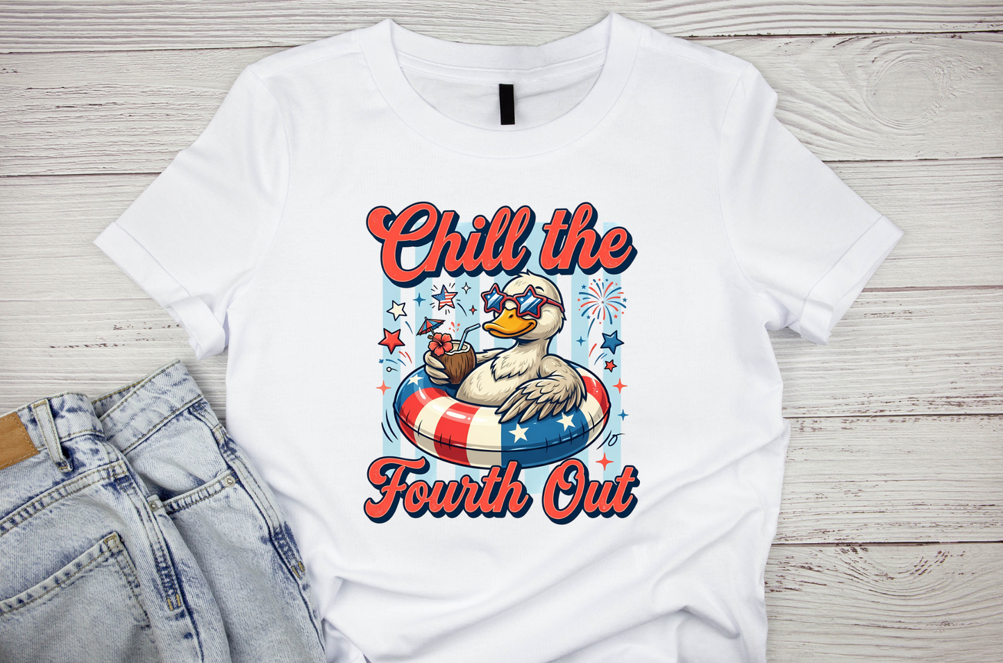 White t-shirt with a graphic of a duck and text 'Chill the Fourth Out' on a wooden surface.