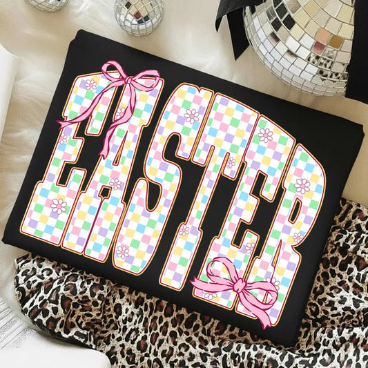 Black pillow with colorful 'Easter' design featuring bows and patterns on a leopard print surface.
