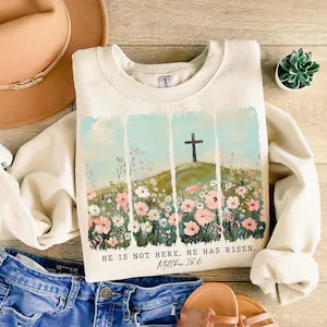 Sweatshirt with a cross and floral design on a wooden surface