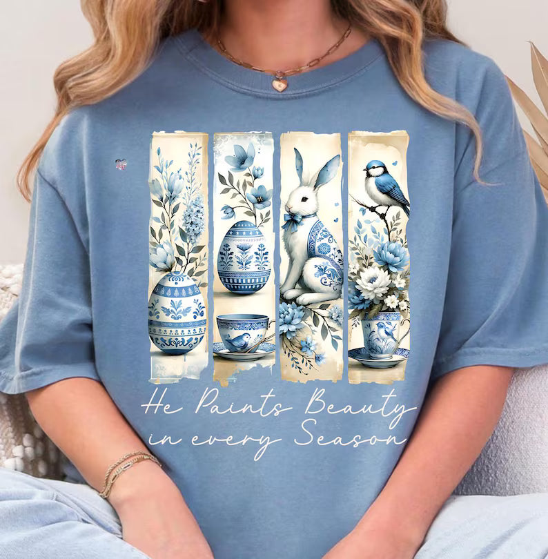 Person wearing a blue t-shirt with artistic designs and text.
