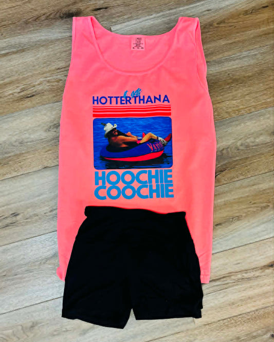 Coral tank top with graphic design and black shorts on a wooden surface