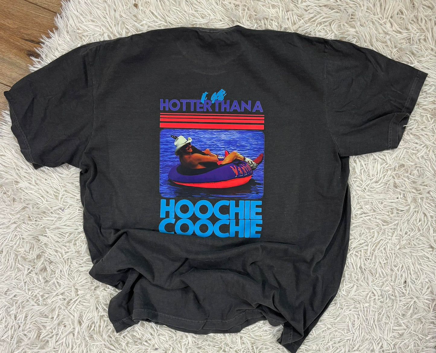 Black t-shirt with a colorful graphic and text on a textured surface