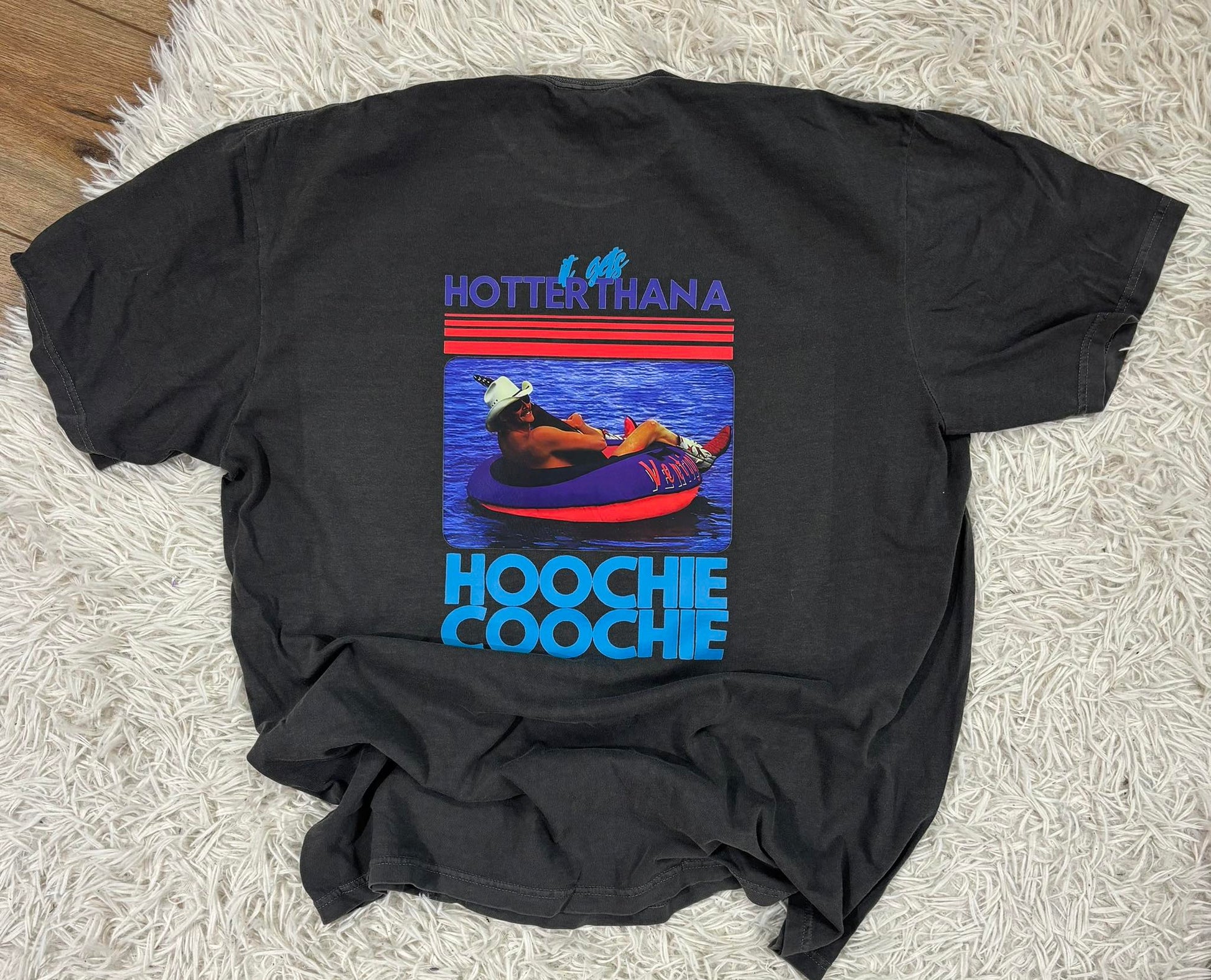 Black t-shirt with a colorful graphic and text on a textured surface