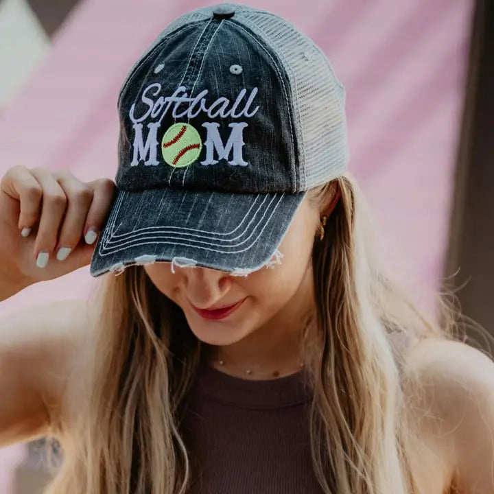 Woman wearing a denim cap with 'Softball Mom' text and a softball graphic.