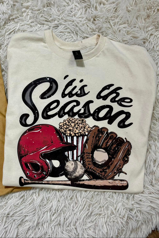 White sweatshirt with sports-themed design and text 'O' is the Season' on a fluffy white surface.