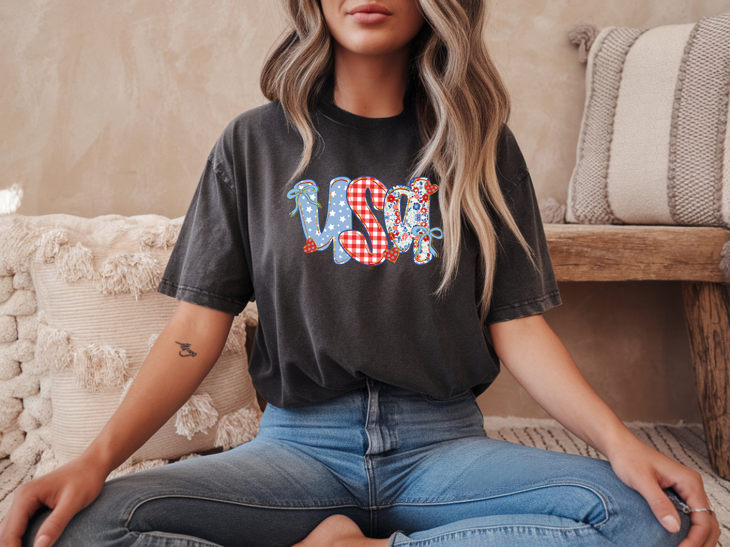 Person wearing a black t-shirt with colorful text sitting on a couch.